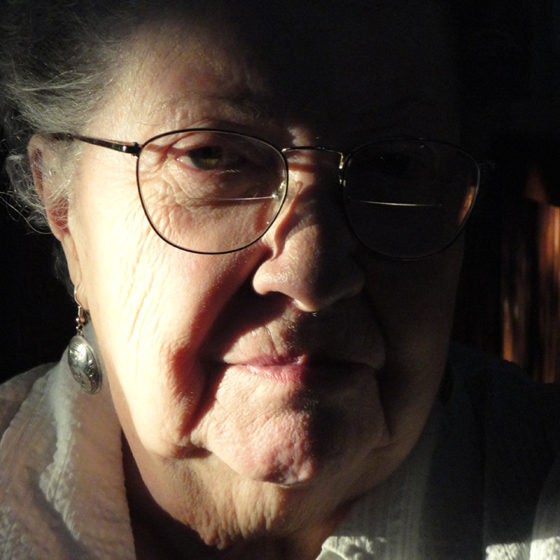 Portrait photograph of older woman sunlight on half of face