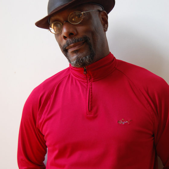 Portrait photograph of African-American man wearing hat in red shirt